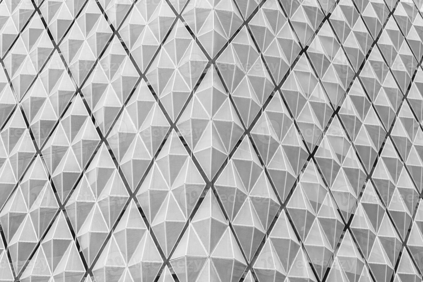 Fragment of a modern building. Abstract geometric background. Part of the facade of a skyscraper with metal diamond-shaped grids. photo