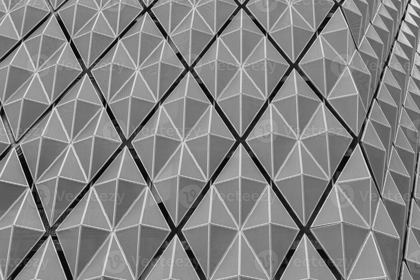 Fragment of a modern building. Abstract geometric background. Part of the facade of a skyscraper with metal diamond-shaped grids. photo