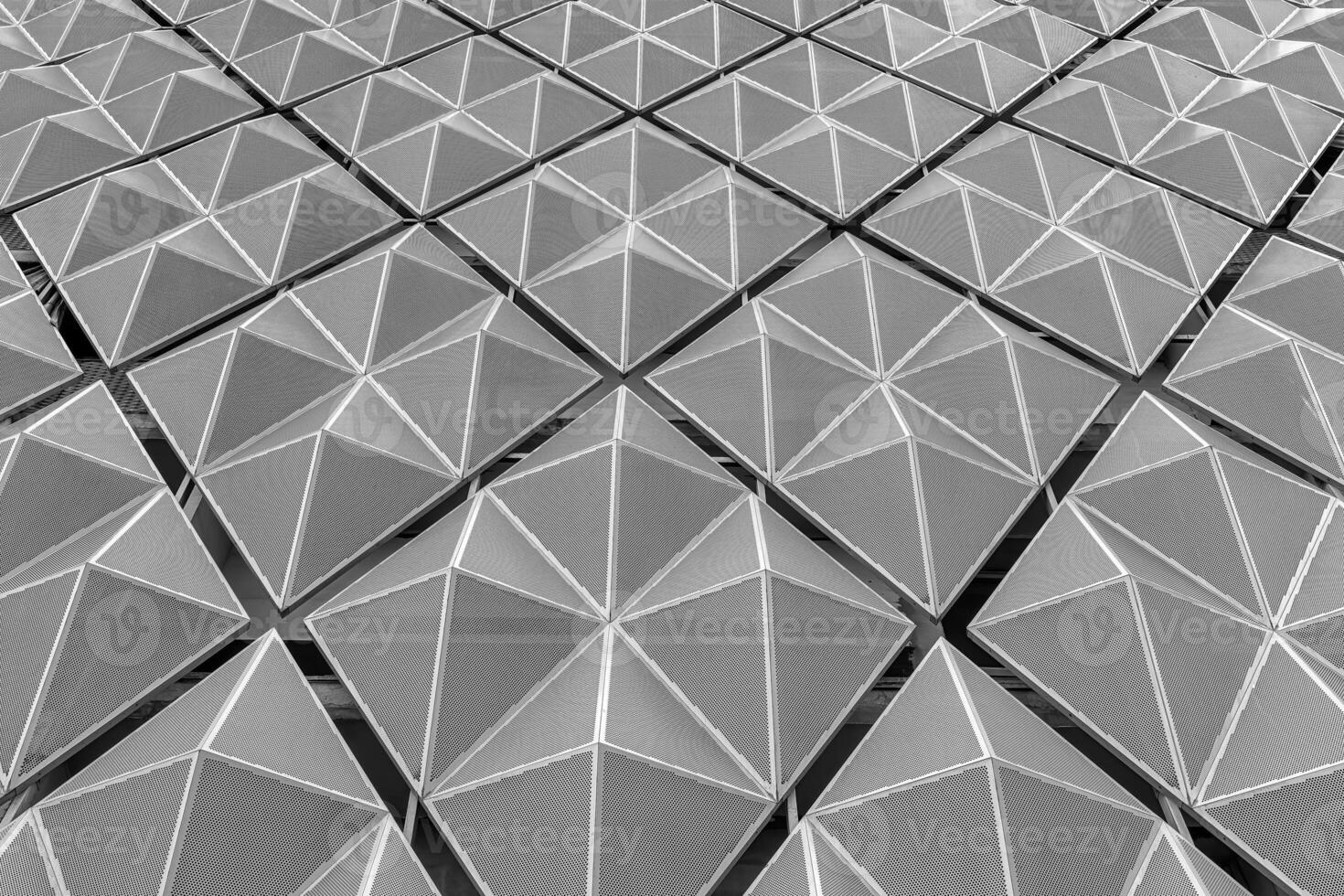 Fragment of a modern building. Abstract geometric background. Part of the facade of a skyscraper with metal diamond-shaped grids. photo