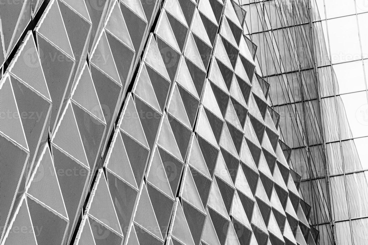 Fragment of a modern building. Abstract geometric background. Part of the facade of a skyscraper with metal diamond-shaped grids. photo