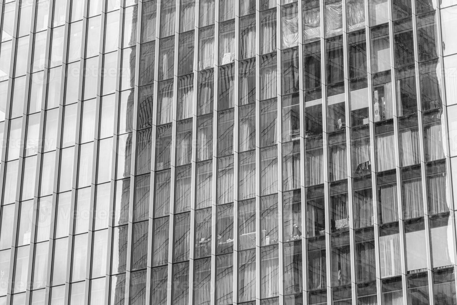 Fragment of a modern office building. Abstract geometric background. Part of a skyscraper with glass windows. Black and white. photo