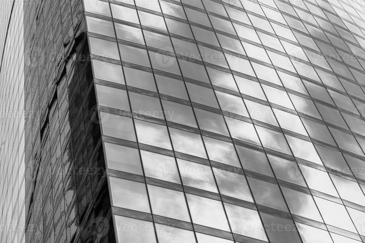 Fragment of a modern office building. Abstract geometric background. Part of a skyscraper with glass windows. Black and white. photo