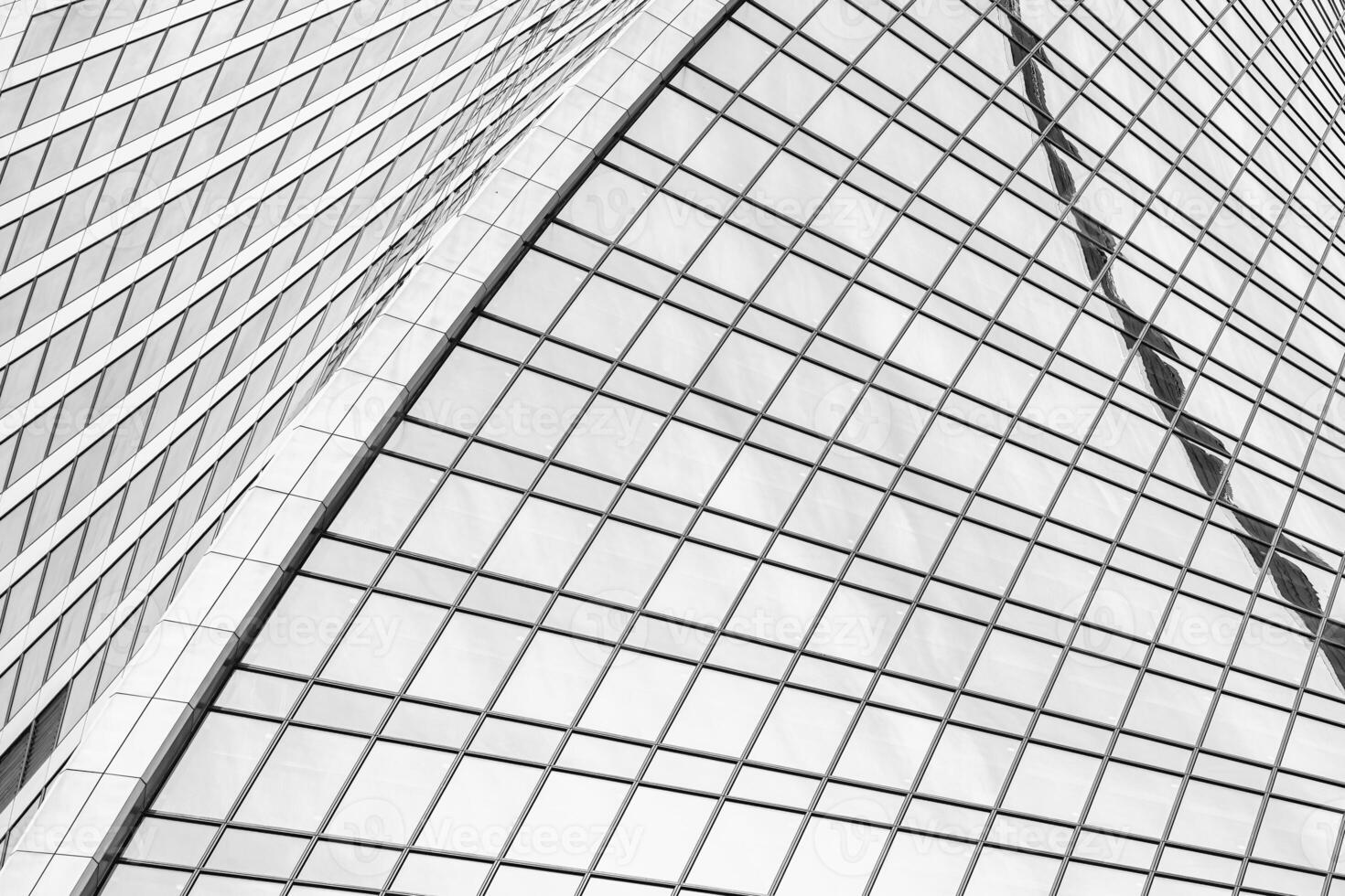 Fragment of a modern office building. Abstract geometric background. Part of a skyscraper with glass windows. Black and white. photo