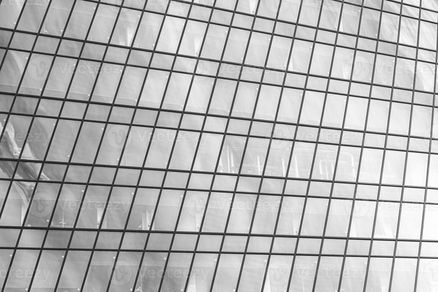 Fragment of a modern office building. Abstract geometric background. Part of a skyscraper with glass windows. Black and white. photo