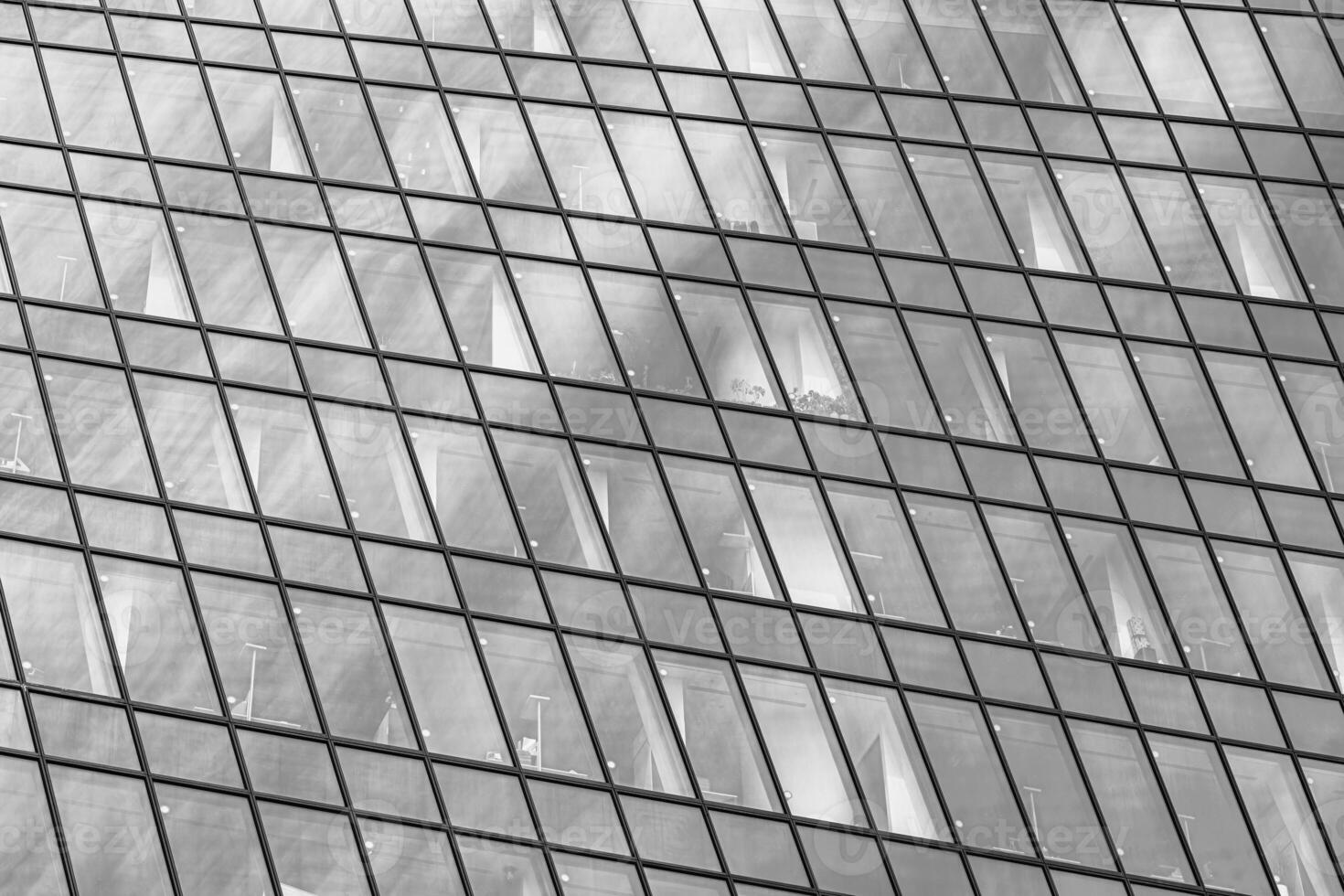 Fragment of a modern office building. Abstract geometric background. Part of a skyscraper with glass windows. Black and white. photo