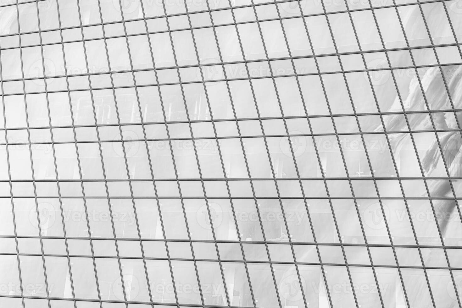 Fragment of a modern office building. Abstract geometric background. Part of a skyscraper with glass windows. Black and white. photo