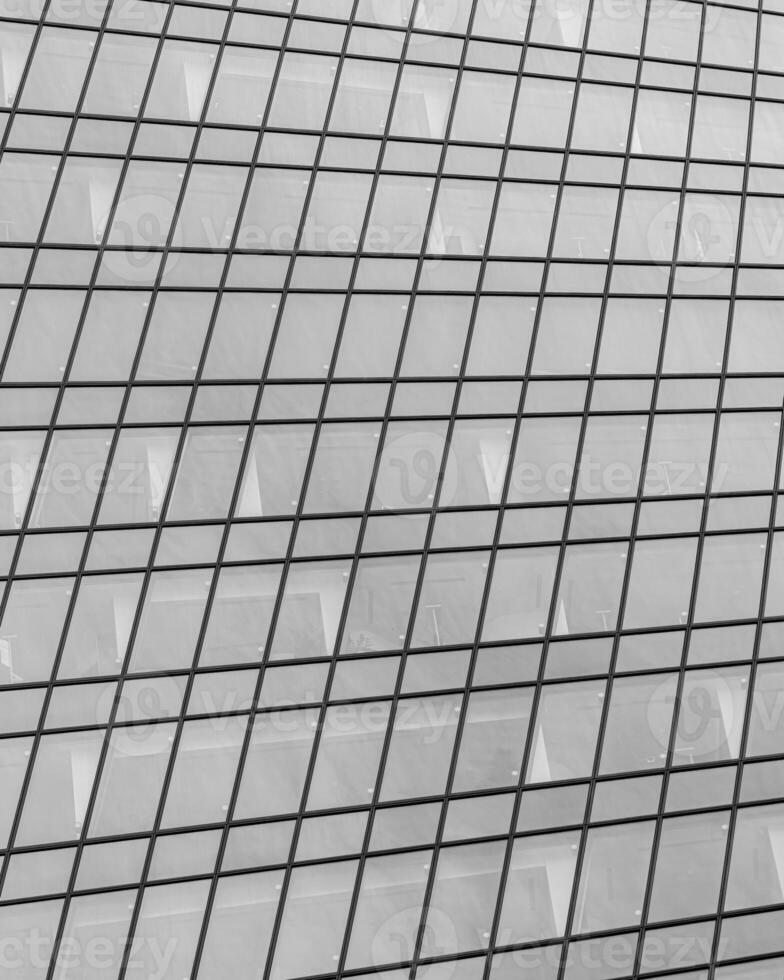Fragment of a modern office building. Abstract geometric background. Part of a skyscraper with glass windows. Black and white. photo