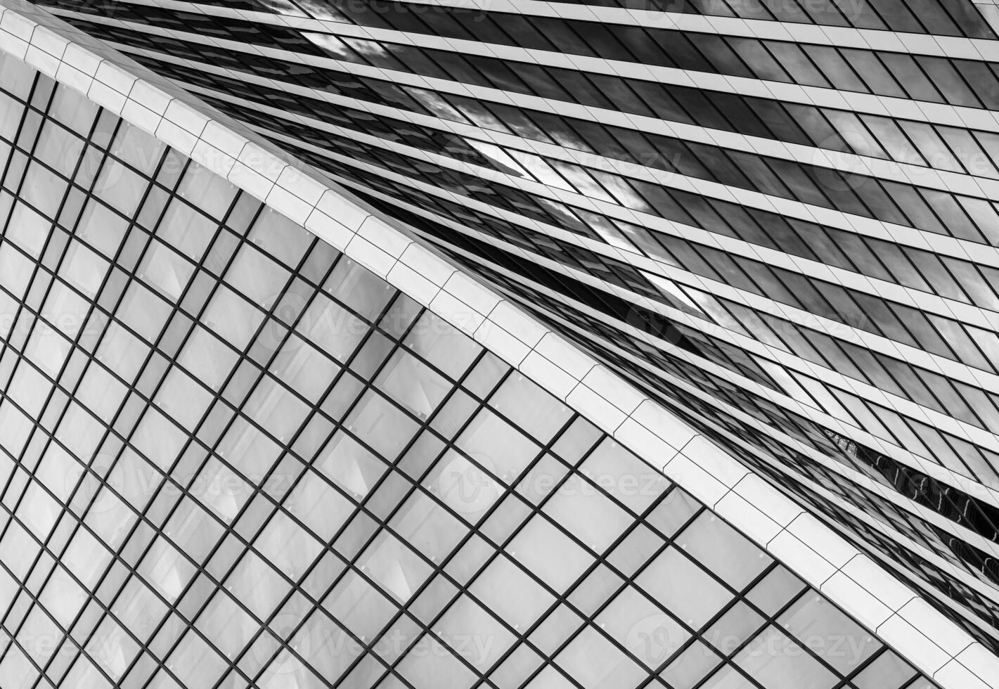 Fragment of a modern office building. Abstract geometric background. Part of a skyscraper with glass windows. Black and white. photo