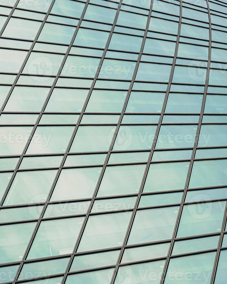 Fragment of a modern office building. Abstract geometric background. Part of a skyscraper with glass windows. photo
