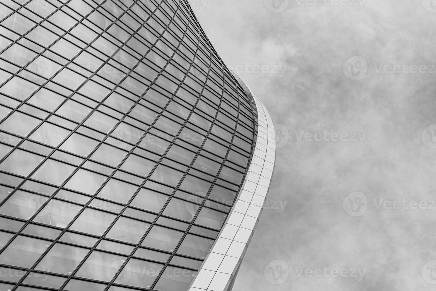 Fragment of a modern office building. Abstract geometric background. Part of a skyscraper with glass windows. Black and white. photo
