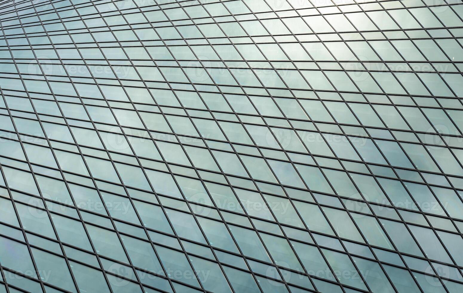 Fragment of a modern office building. Abstract geometric background. Part of a skyscraper with glass windows. photo