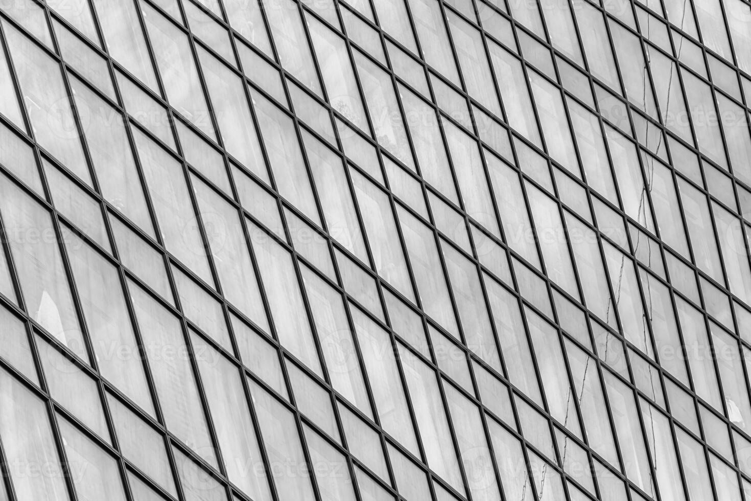 Fragment of a modern office building. Abstract geometric background. Part of a skyscraper with glass windows. Black and white. photo