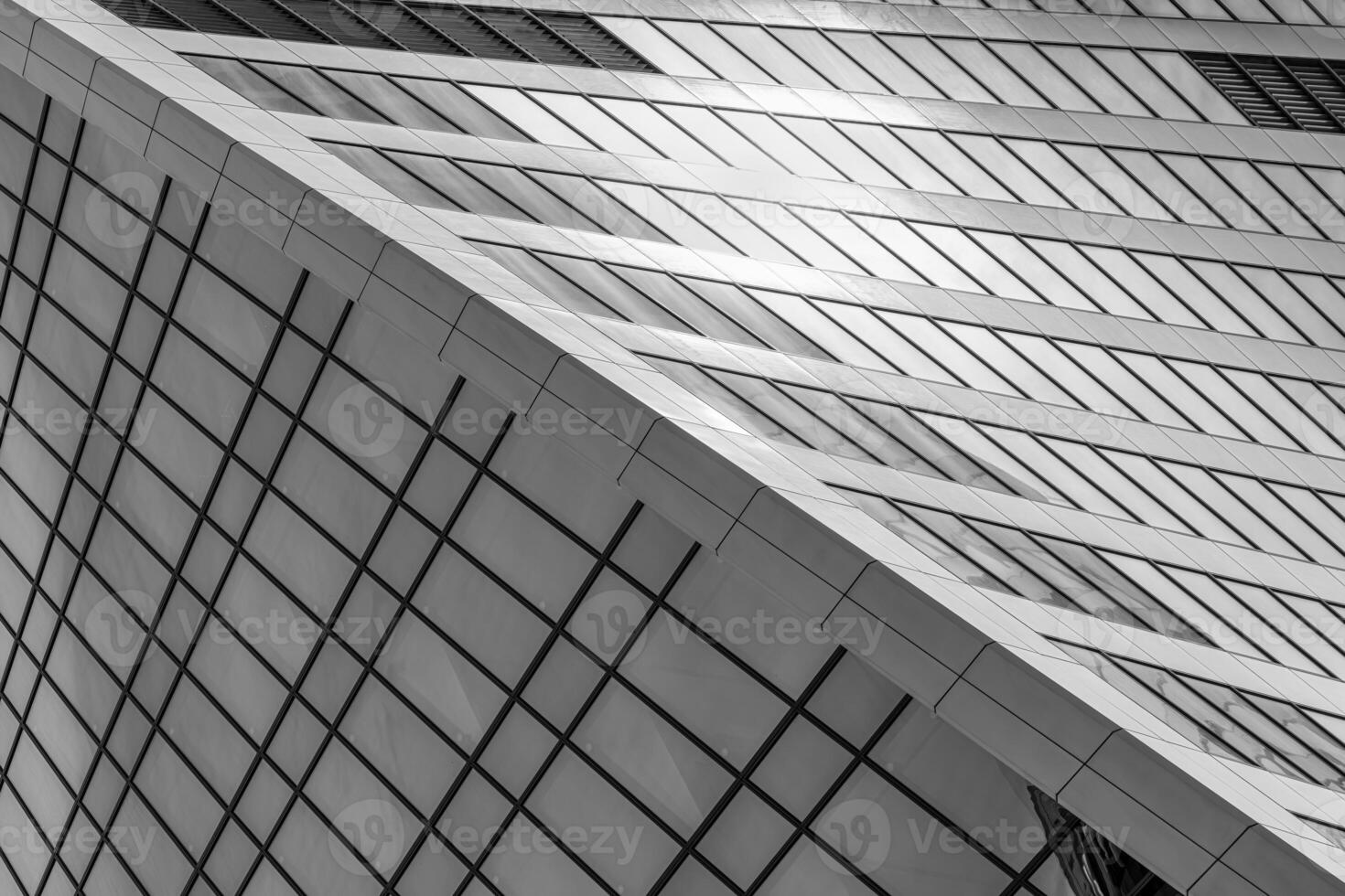 Fragment of a modern office building. Abstract geometric background. Part of a skyscraper with glass windows. Black and white. photo