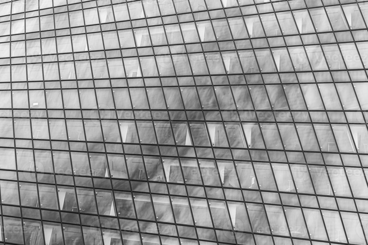 Fragment of a modern office building. Abstract geometric background. Part of a skyscraper with glass windows. Black and white. photo