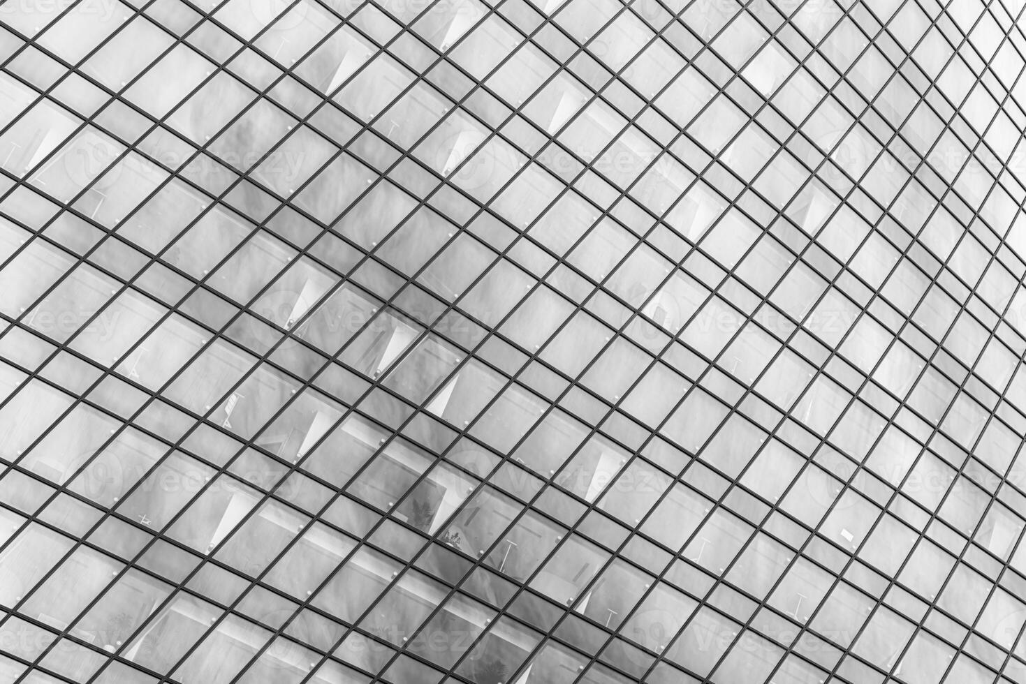 Fragment of a modern office building. Abstract geometric background. Part of a skyscraper with glass windows. Black and white. photo