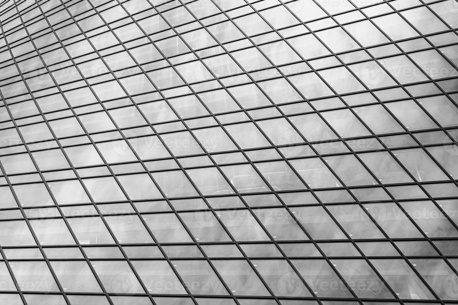 Fragment of a modern office building. Abstract geometric background. Part of a skyscraper with glass windows. Black and white. photo