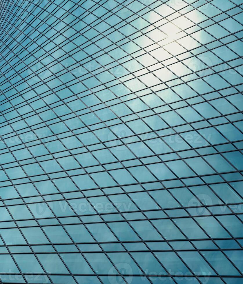 Fragment of a modern office building. Abstract geometric background. Part of a skyscraper with glass windows. photo