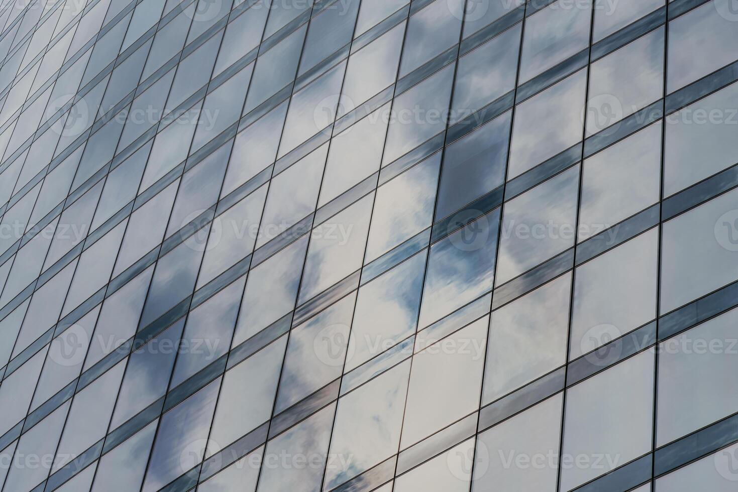 Fragment of a modern office building. Abstract geometric background. Part of a skyscraper with glass windows. photo