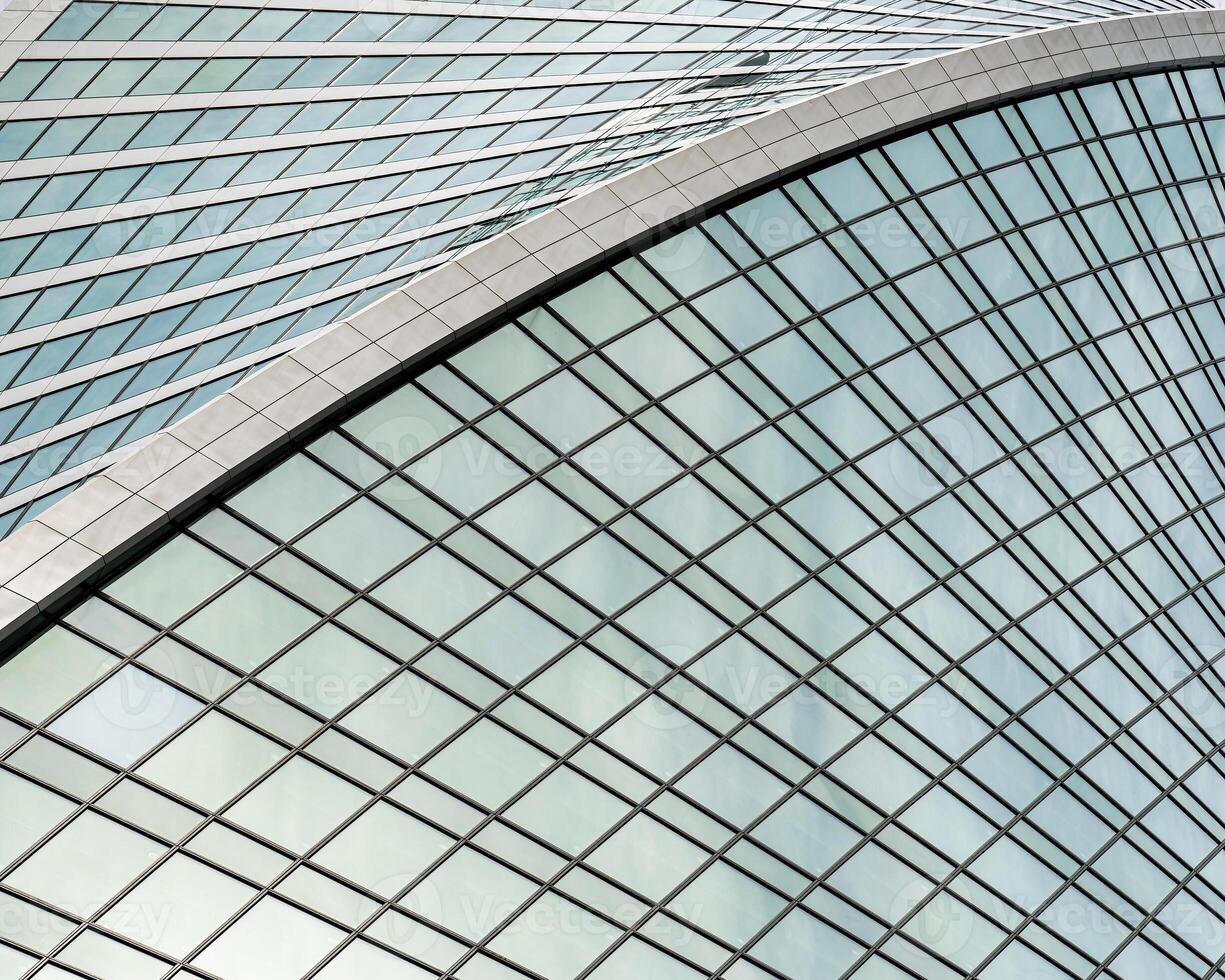 Fragment of a modern office building. Abstract geometric background. Part of a skyscraper with glass windows. photo