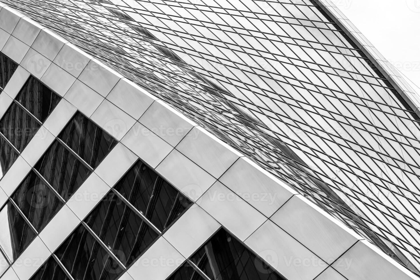 Fragment of a modern office building. Abstract geometric background. Part of a skyscraper with glass windows. Black and white. photo