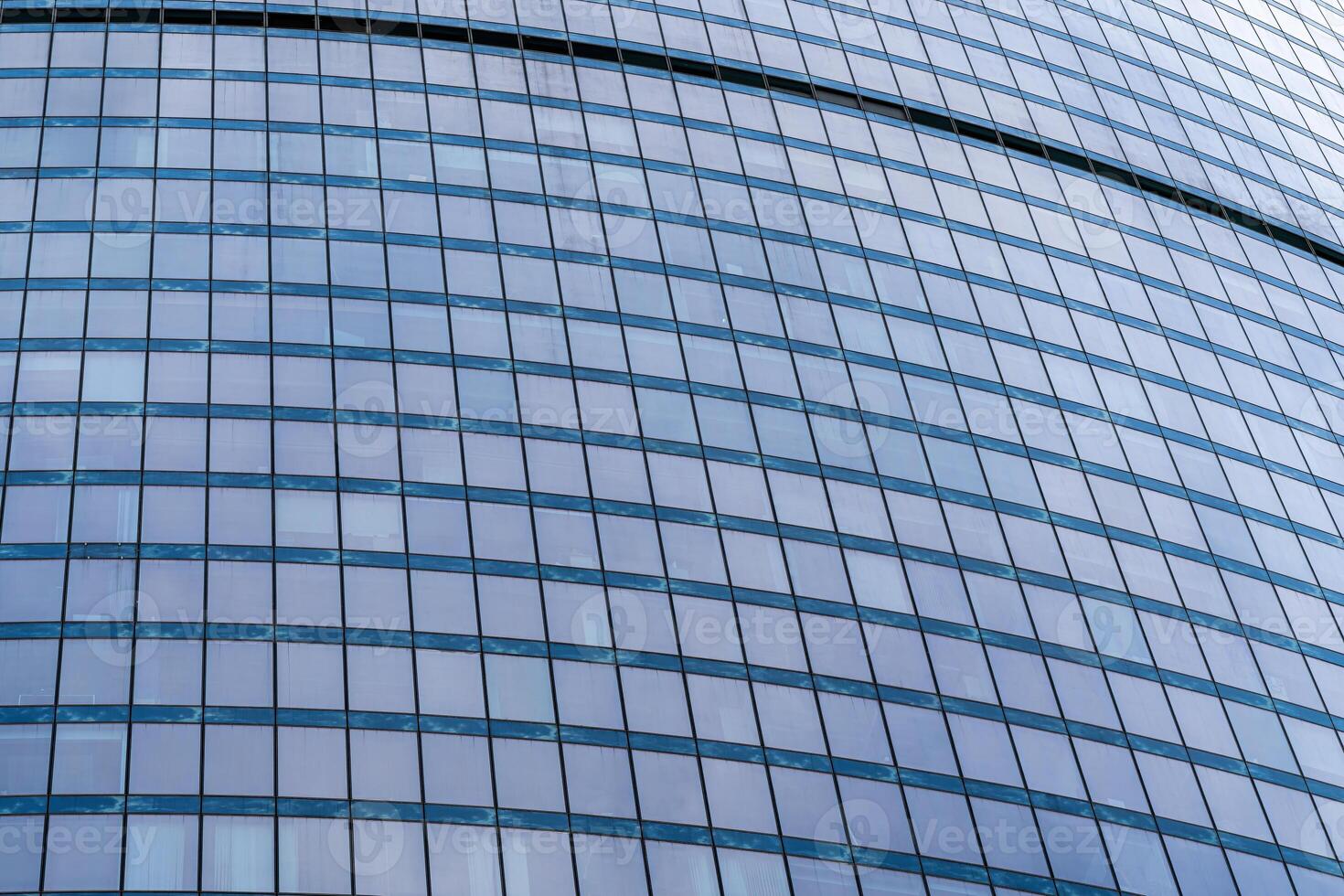 Fragment of a modern office building. Abstract geometric background. Part of a skyscraper with glass windows. photo