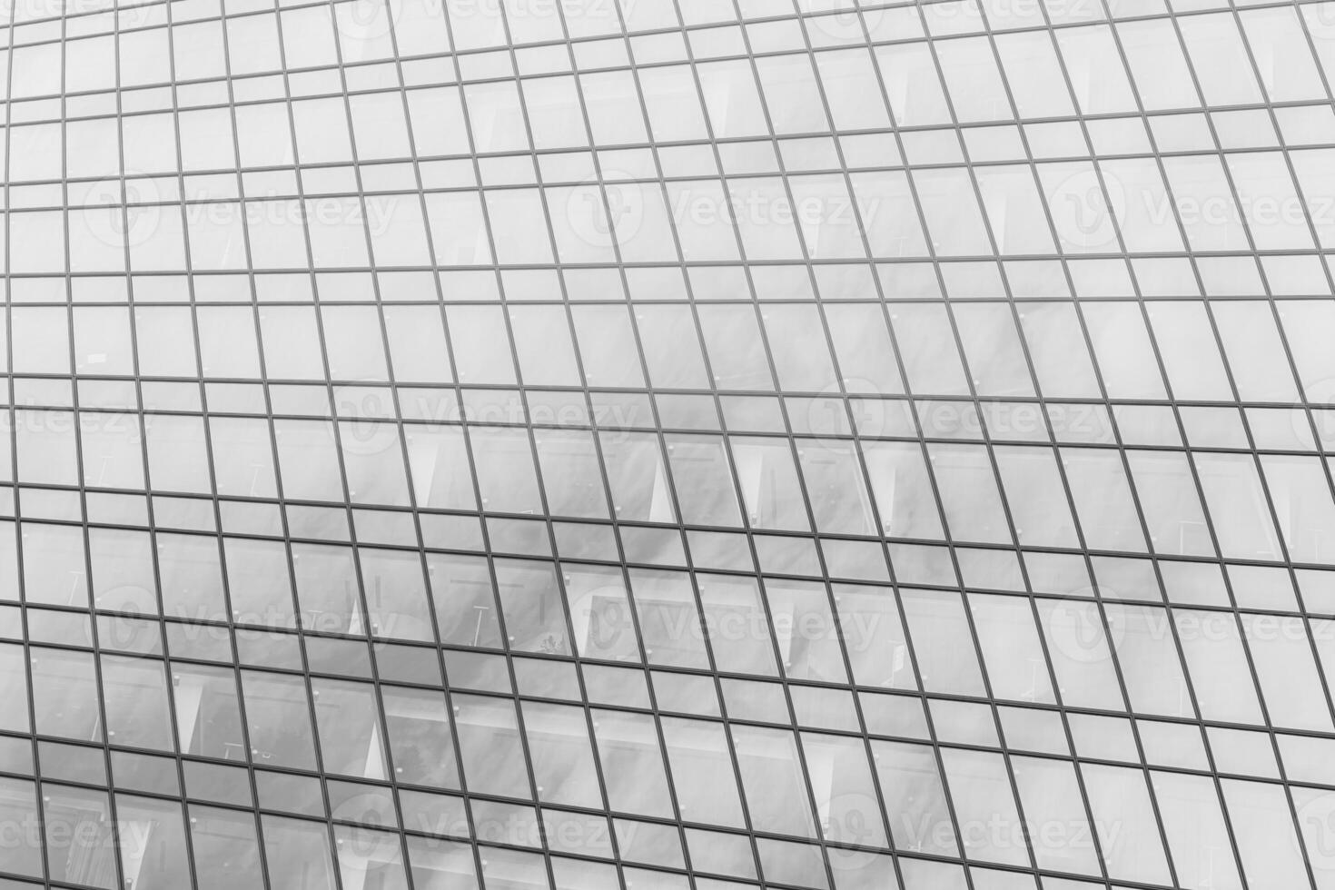 Fragment of a modern office building. Abstract geometric background. Part of a skyscraper with glass windows. Black and white. photo
