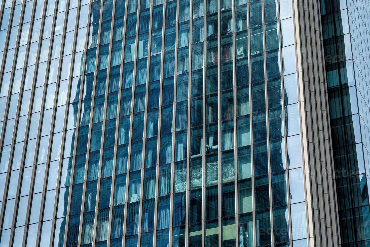 Fragment of a modern office building. Abstract geometric background. Part of a skyscraper with glass windows. photo