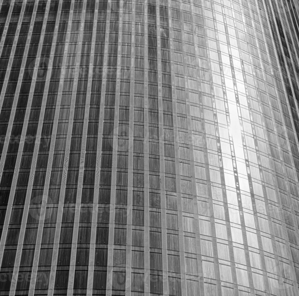 Fragment of a modern office building. Abstract geometric background. Part of a skyscraper with glass windows. Black and white. photo