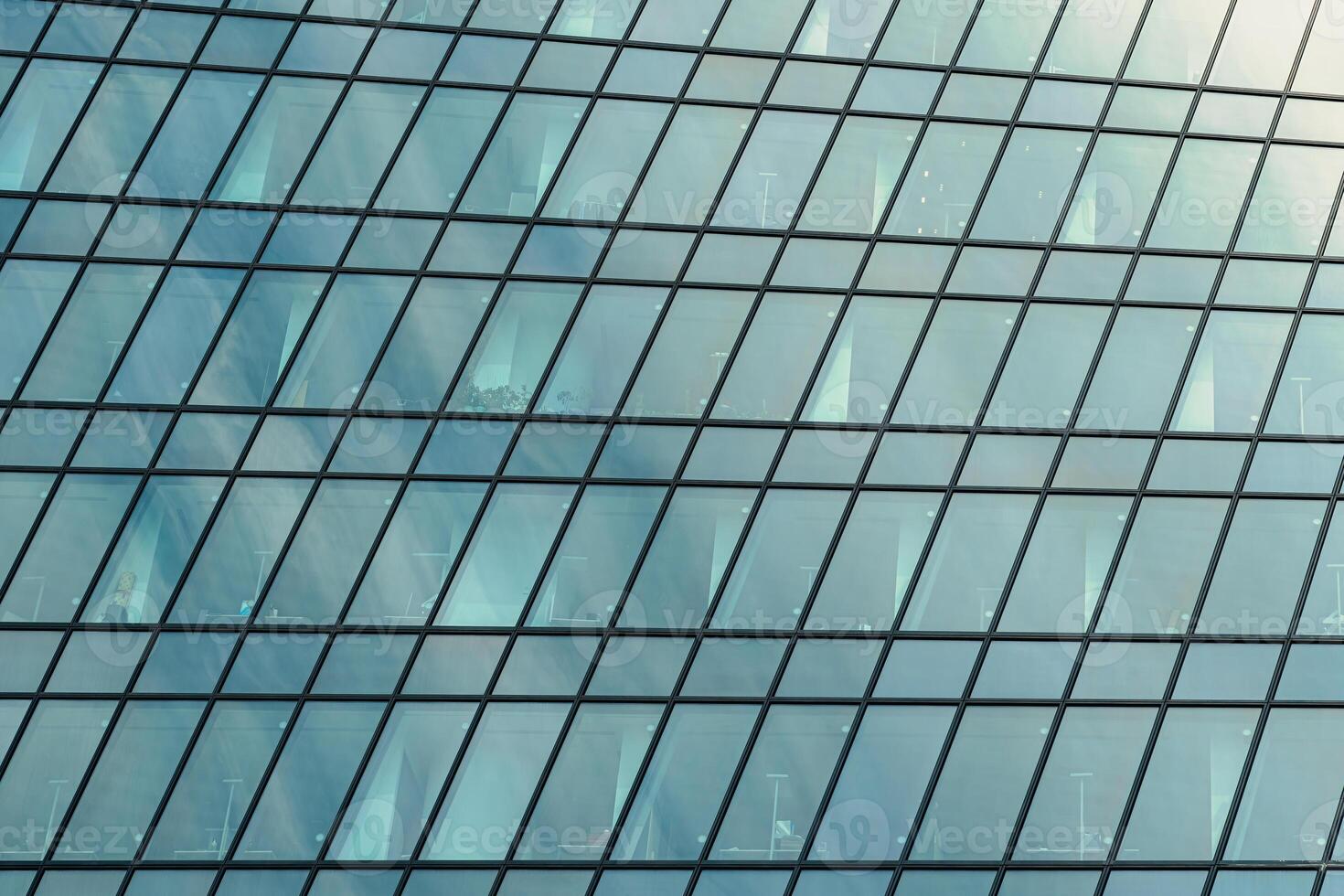 Fragment of a modern office building. Abstract geometric background. Part of a skyscraper with glass windows. photo