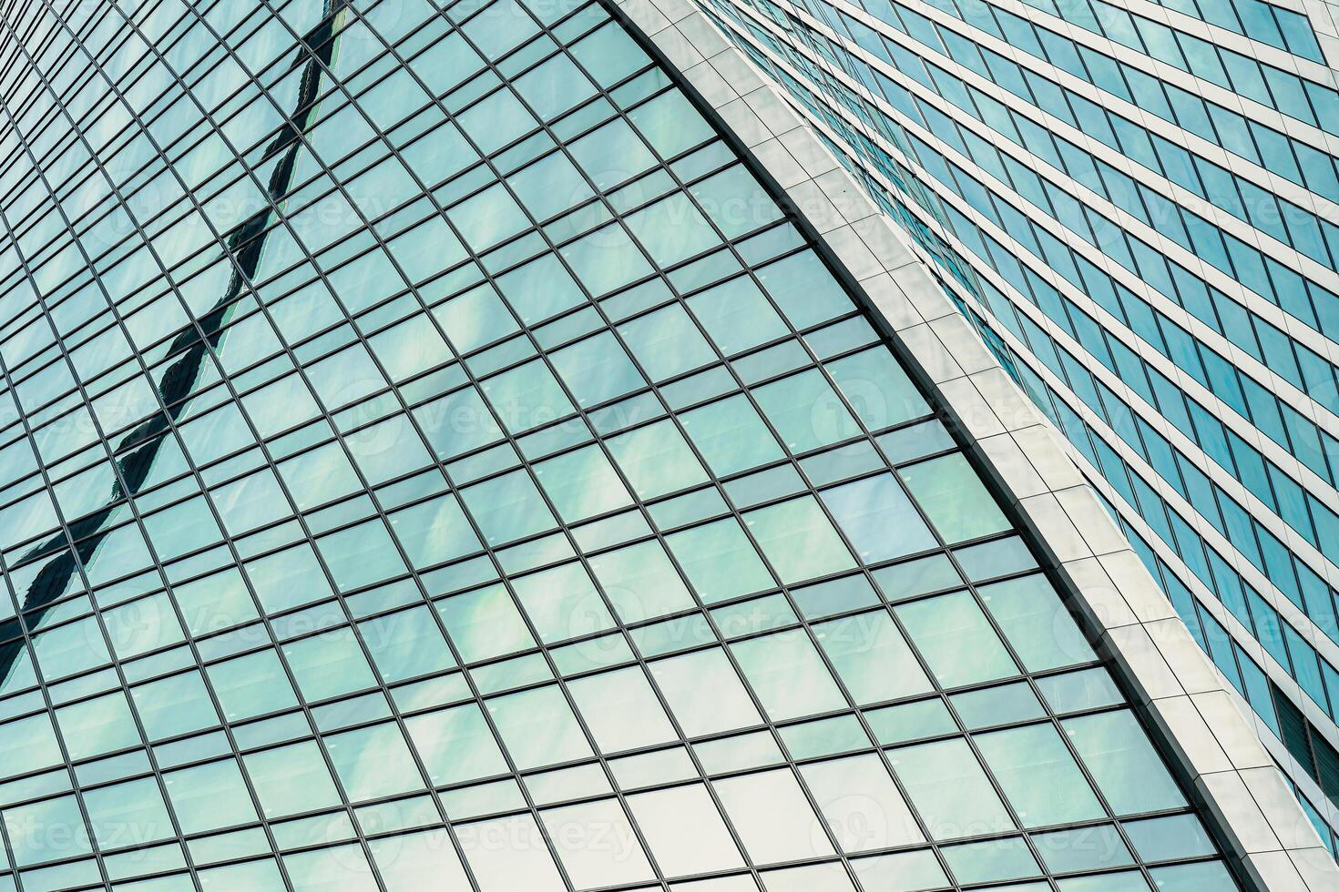 Fragment of a modern office building. Abstract geometric background. Part of a skyscraper with glass windows. photo
