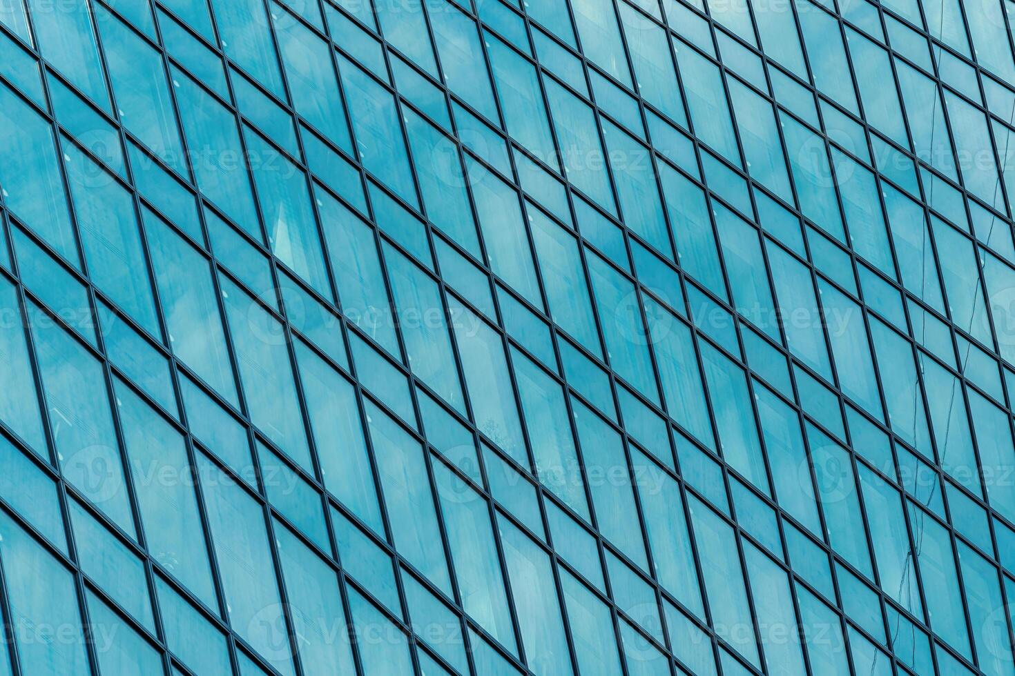 Fragment of a modern office building. Abstract geometric background. Part of a skyscraper with glass windows. photo