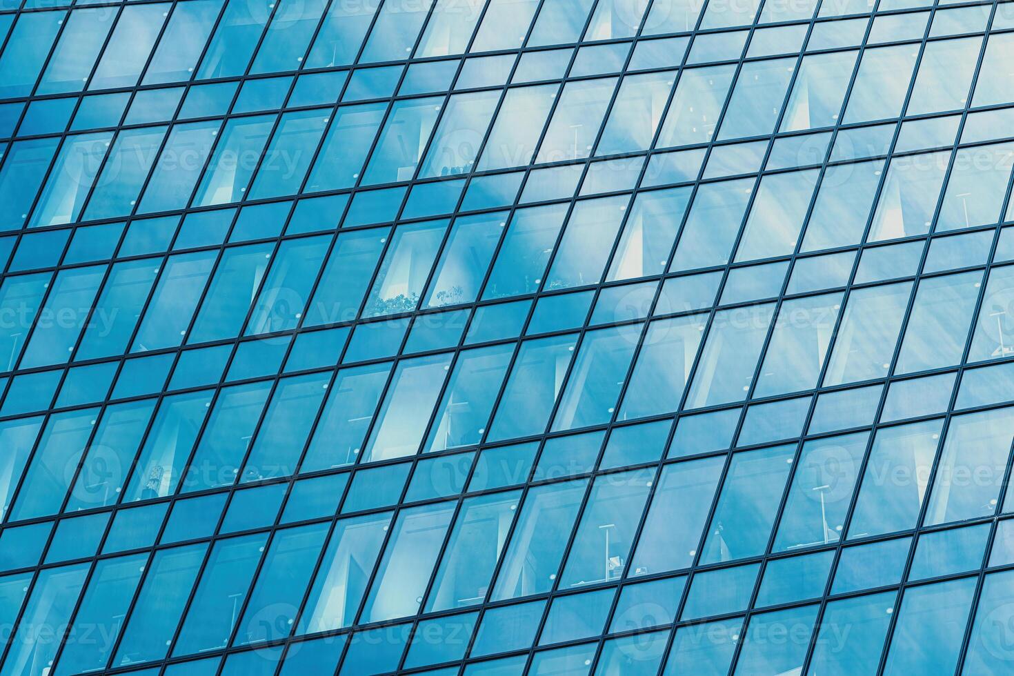 Fragment of a modern office building. Abstract geometric background. Part of a skyscraper with glass windows. photo