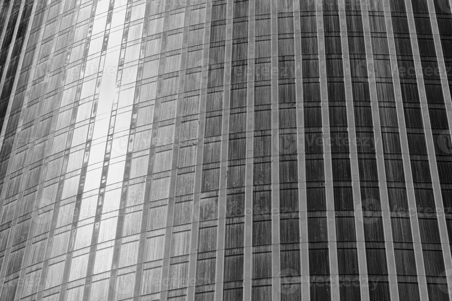 Fragment of a modern office building. Abstract geometric background. Part of a skyscraper with glass windows. Black and white. photo