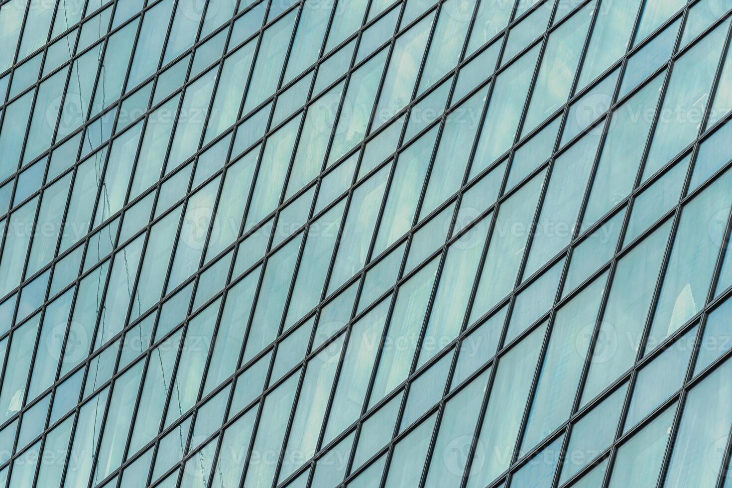 Fragment of a modern office building. Abstract geometric background. Part of a skyscraper with glass windows. photo