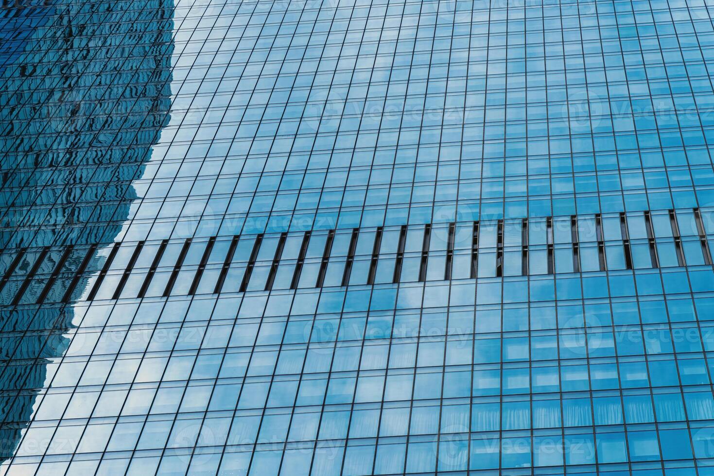 Fragment of a modern office building. Abstract geometric background. Part of a skyscraper with glass windows. photo