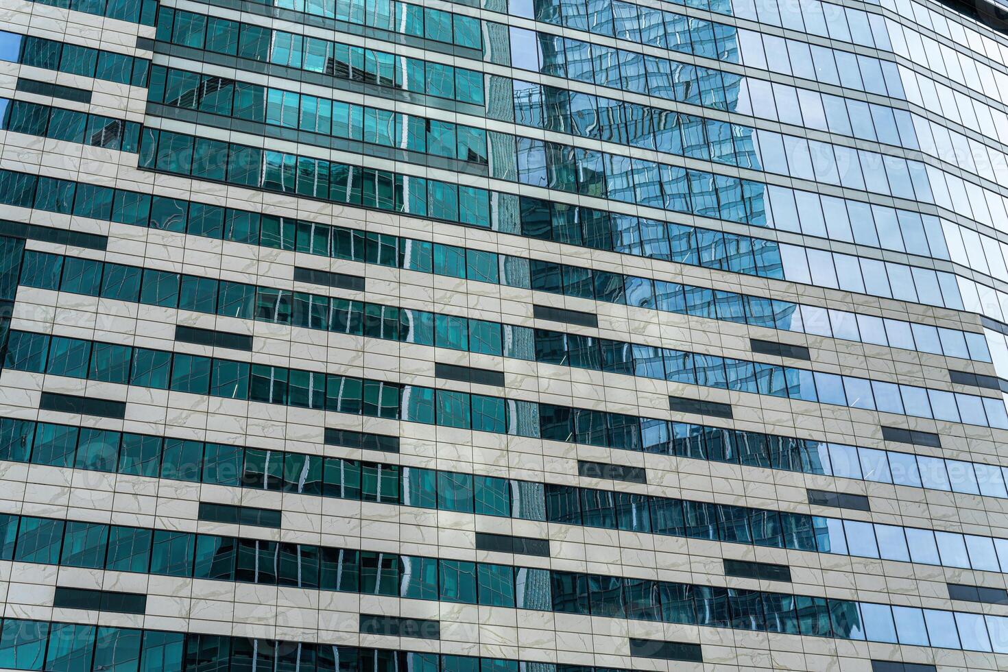 Fragment of a modern office building. Abstract geometric background. Part of a skyscraper with glass windows. photo