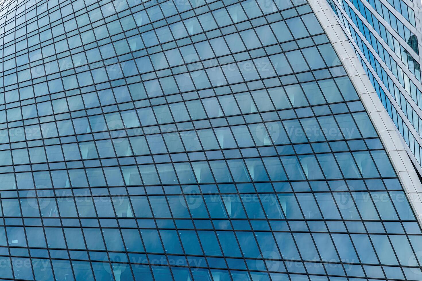 Fragment of a modern office building. Abstract geometric background. Part of a skyscraper with glass windows. photo
