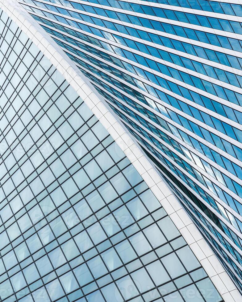 Fragment of a modern office building. Abstract geometric background. Part of a skyscraper with glass windows. photo