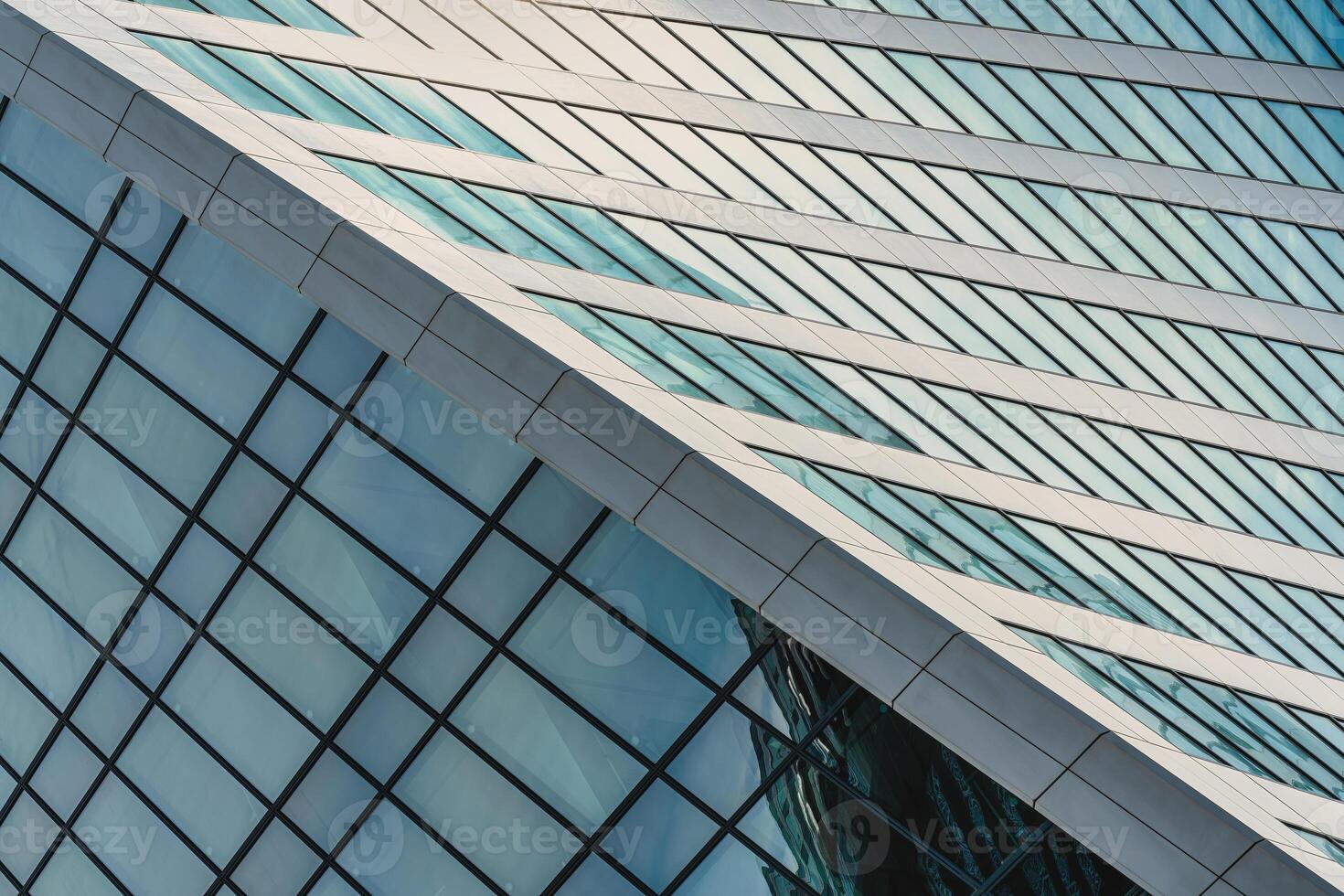 Fragment of a modern office building. Abstract geometric background. Part of a skyscraper with glass windows. photo