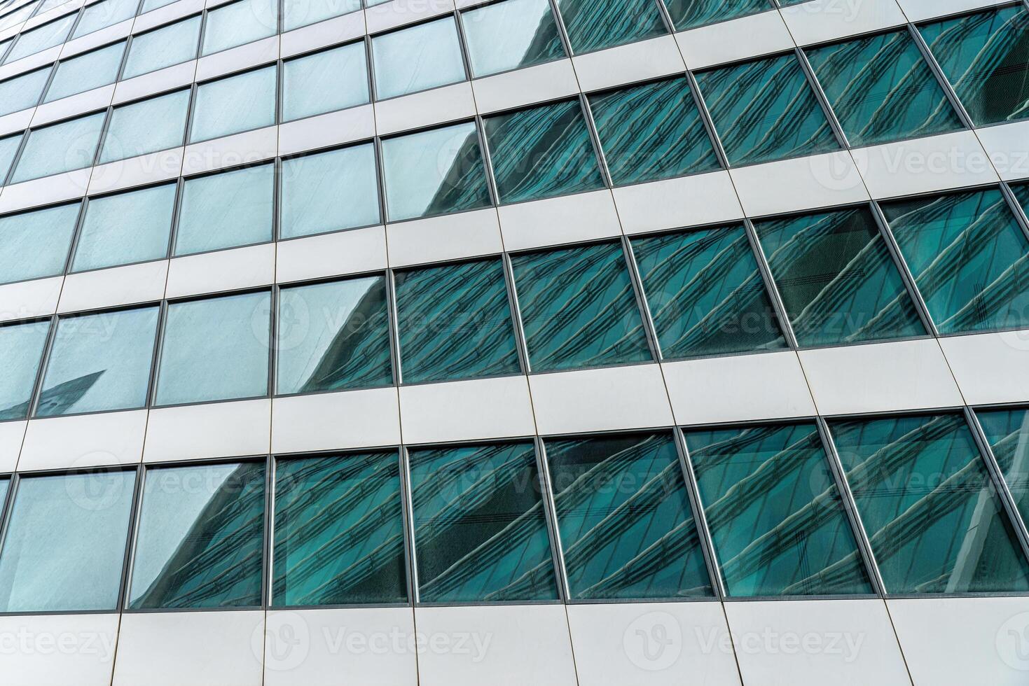 Fragment of a modern office building. Abstract geometric background. Part of a skyscraper with glass windows. photo