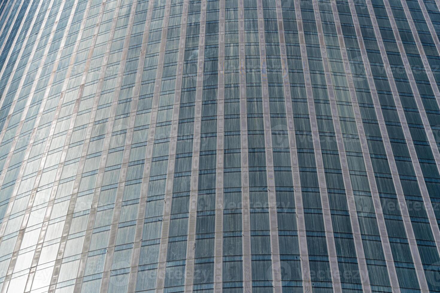 Fragment of a modern office building. Abstract geometric background. Part of a skyscraper with glass windows. photo