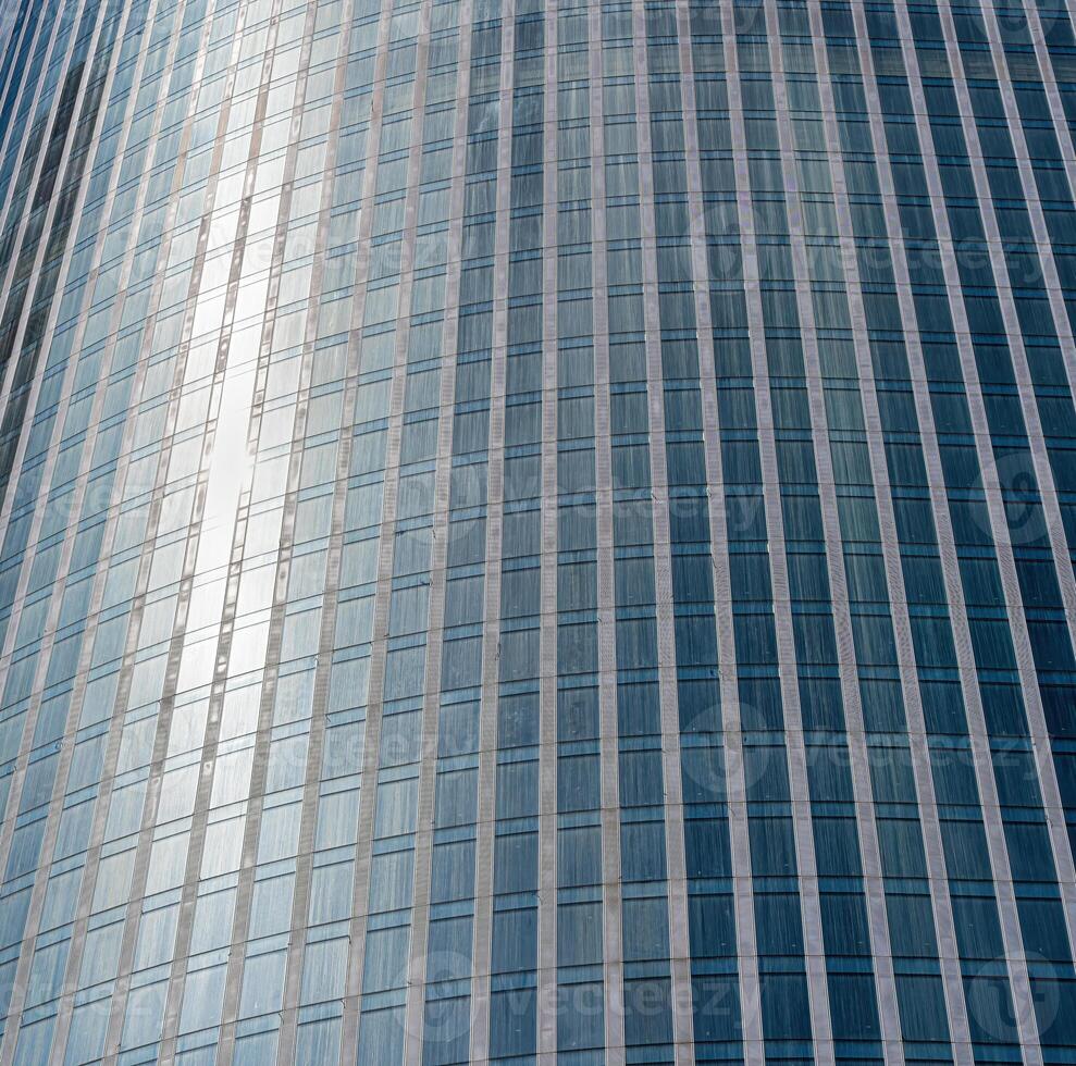 Fragment of a modern office building. Abstract geometric background. Part of a skyscraper with glass windows. photo
