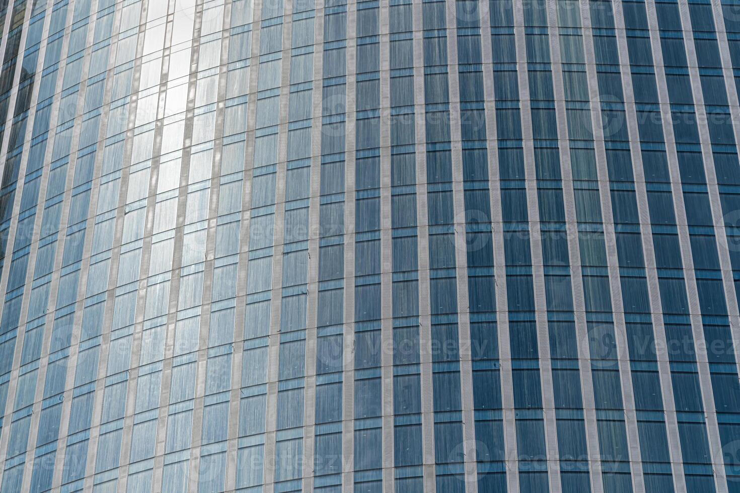 Fragment of a modern office building. Abstract geometric background. Part of a skyscraper with glass windows. photo