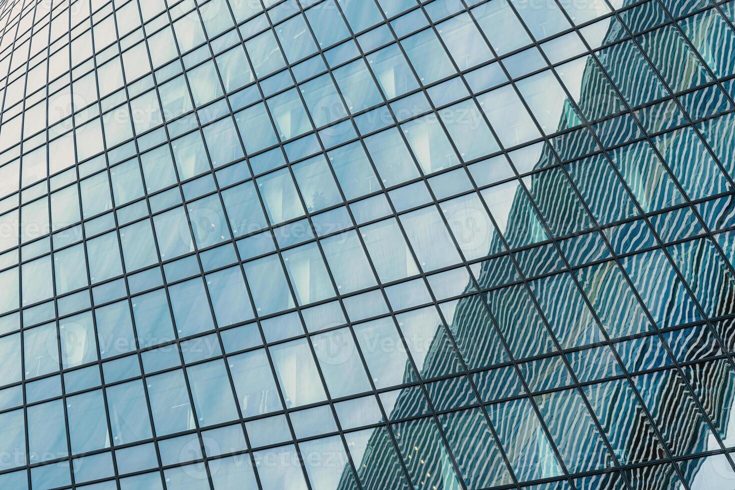 Fragment of a modern office building. Abstract geometric background. Part of a skyscraper with glass windows. photo