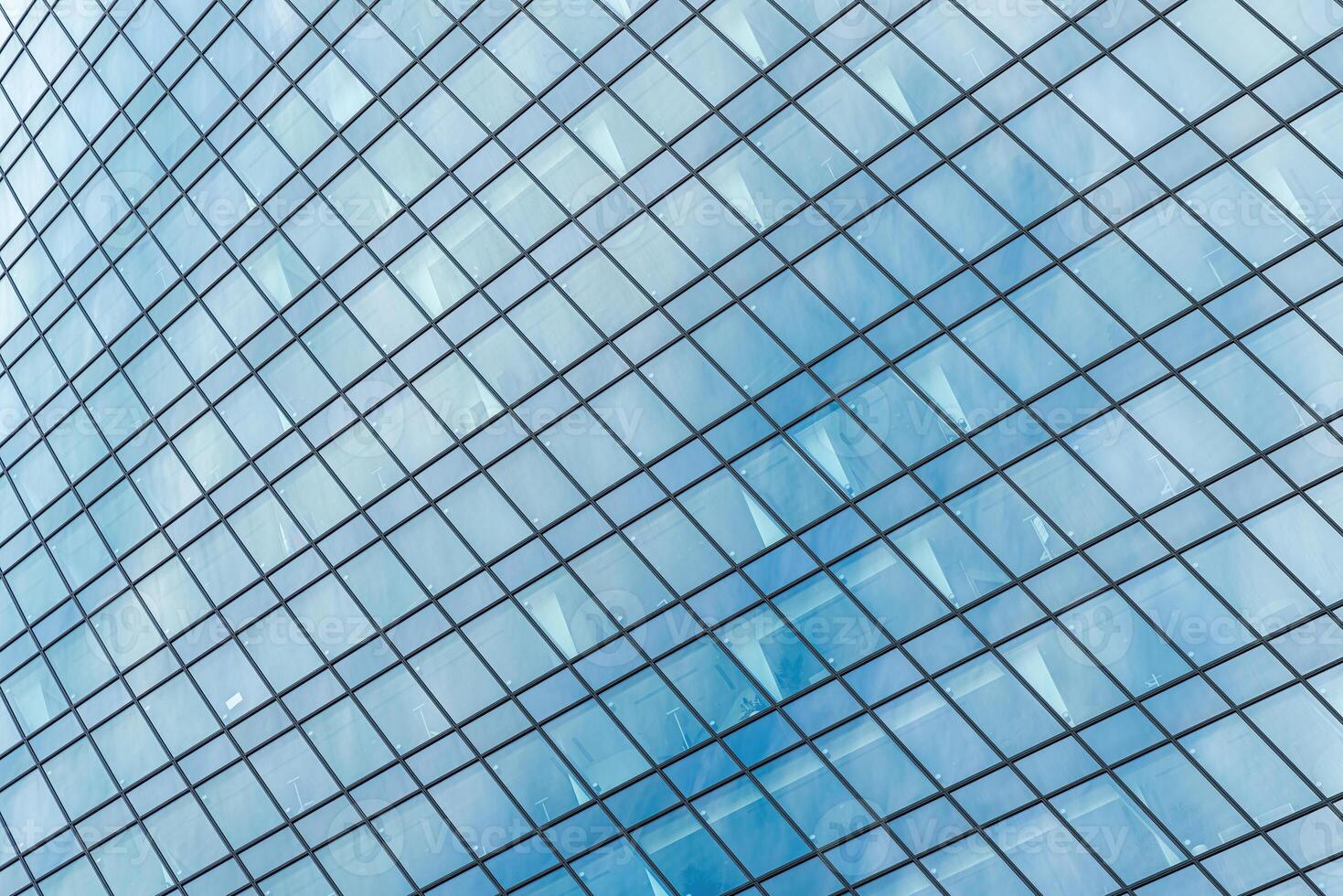 Fragment of a modern office building. Abstract geometric background. Part of a skyscraper with glass windows. photo