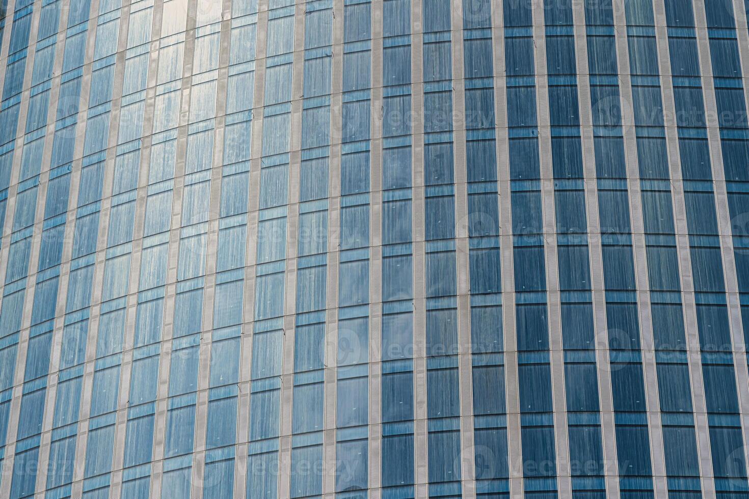 Fragment of a modern office building. Abstract geometric background. Part of a skyscraper with glass windows. photo