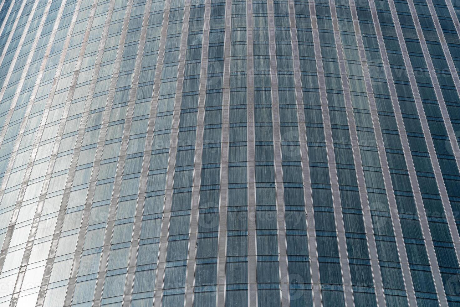 Fragment of a modern office building. Abstract geometric background. Part of a skyscraper with glass windows. photo