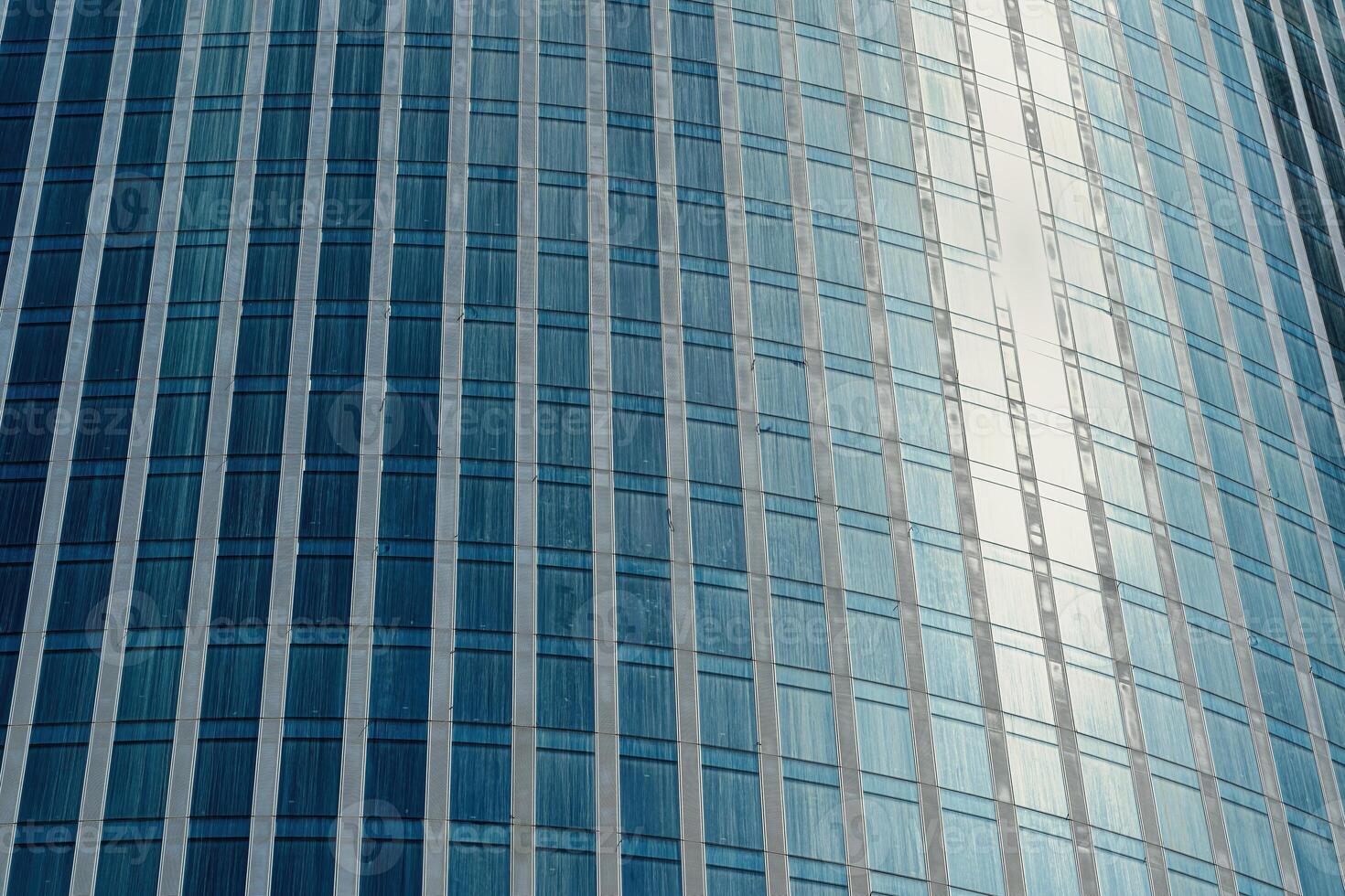 Fragment of a modern office building. Abstract geometric background. Part of a skyscraper with glass windows. photo