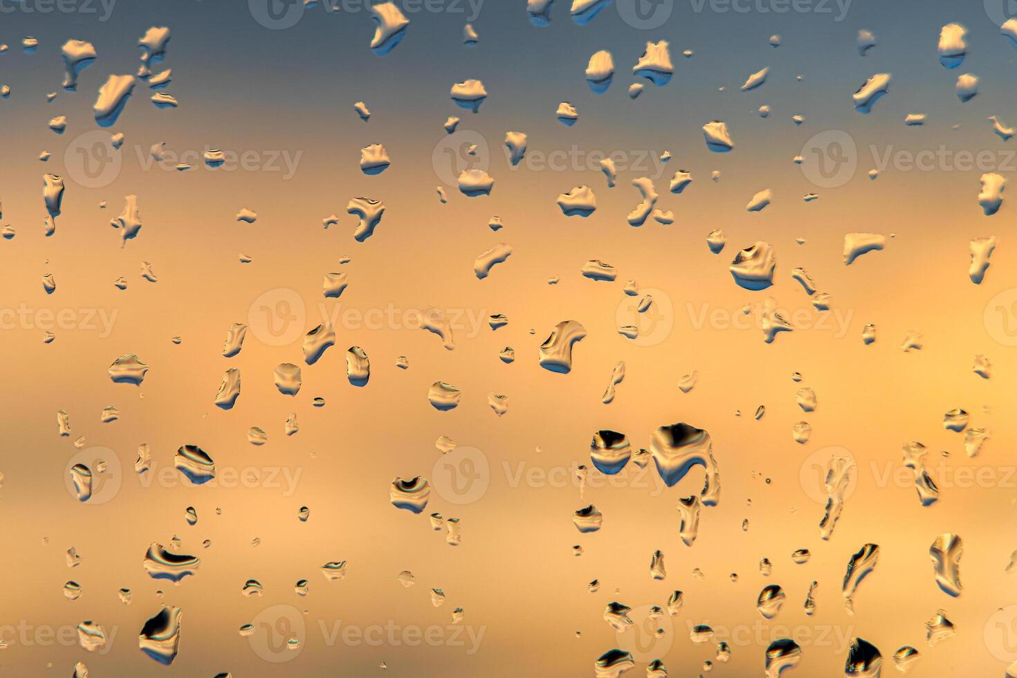 Raindrops on a window with a sunset sky in the background. photo