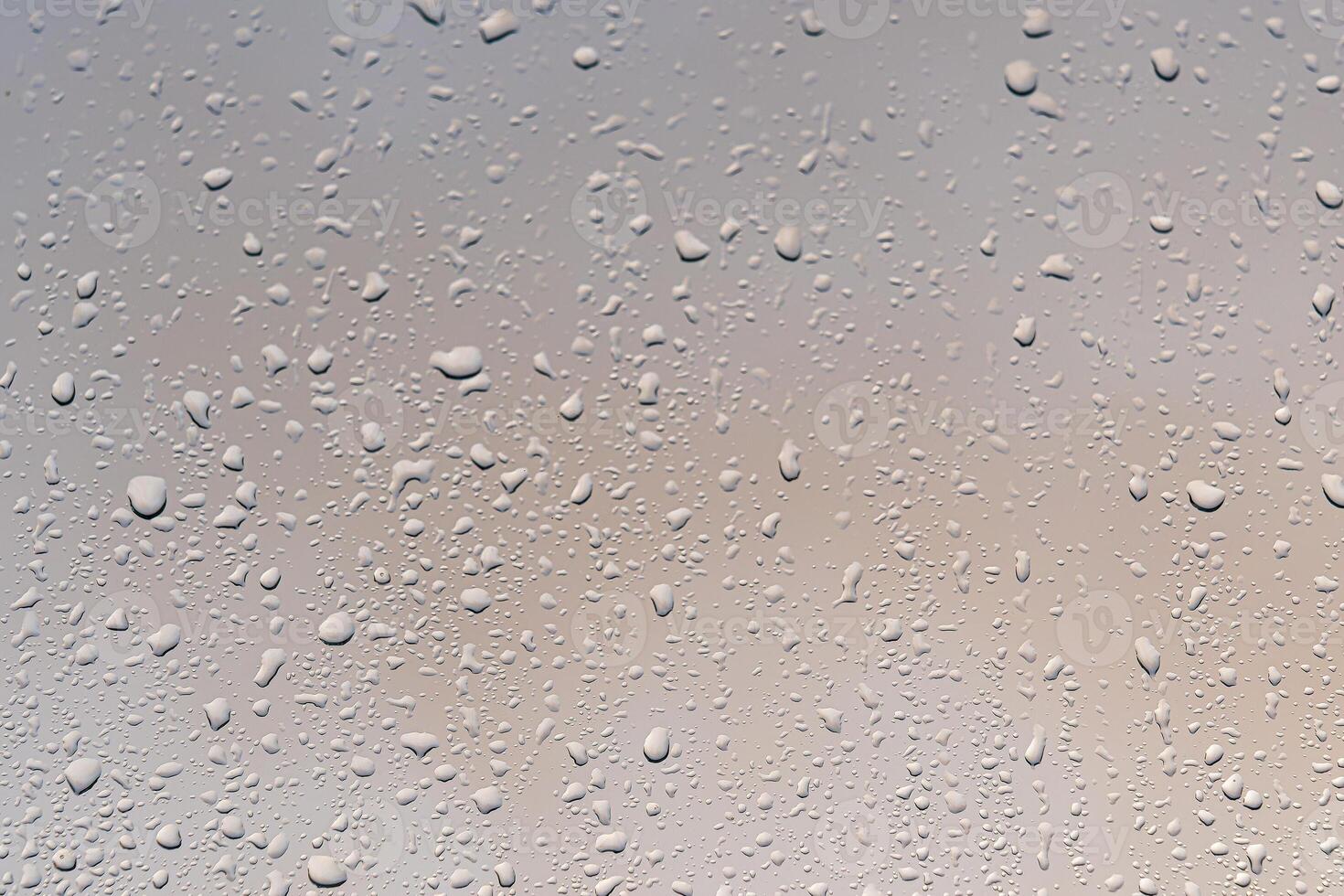 Raindrops on a window with a sunset sky in the background. photo